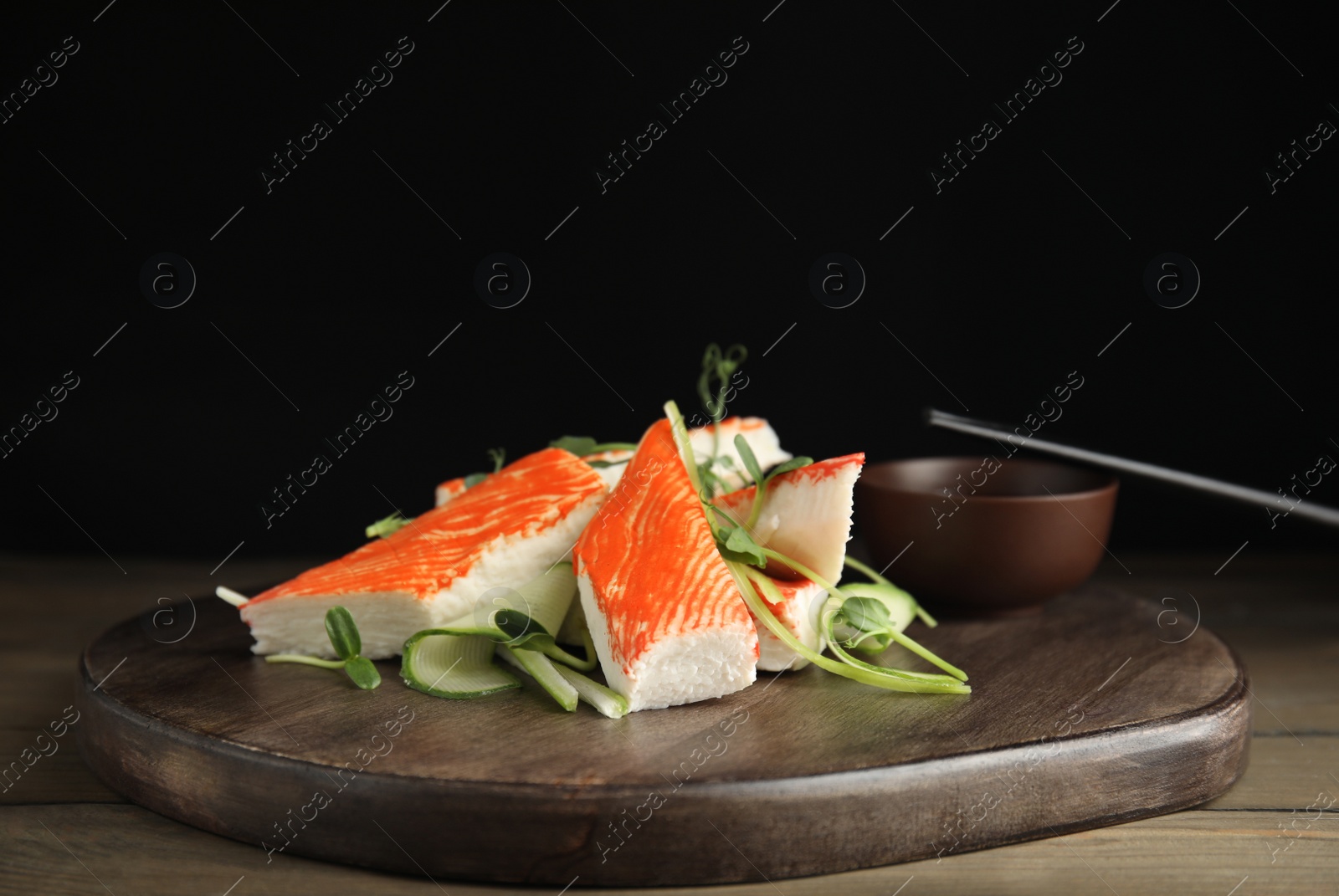 Fresh crab sticks with cucumber and soy sauce served on wooden table Photo of Fresh crab sticks with cucumber and soy sauce served on wooden table