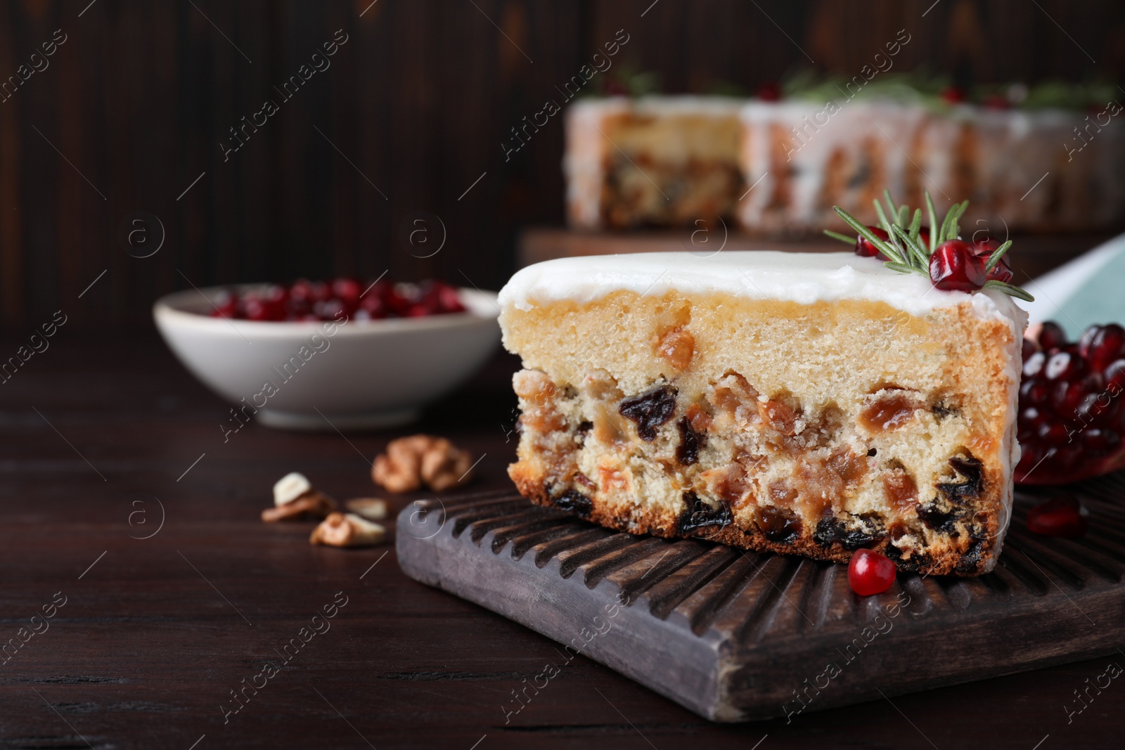 Piece of traditional homemade Christmas cake and fresh pomegranate on wooden table, closeup. Space for text Photo of Piece of traditional homemade Christmas cake and fresh pomegranate on wooden table, closeup. Space for text