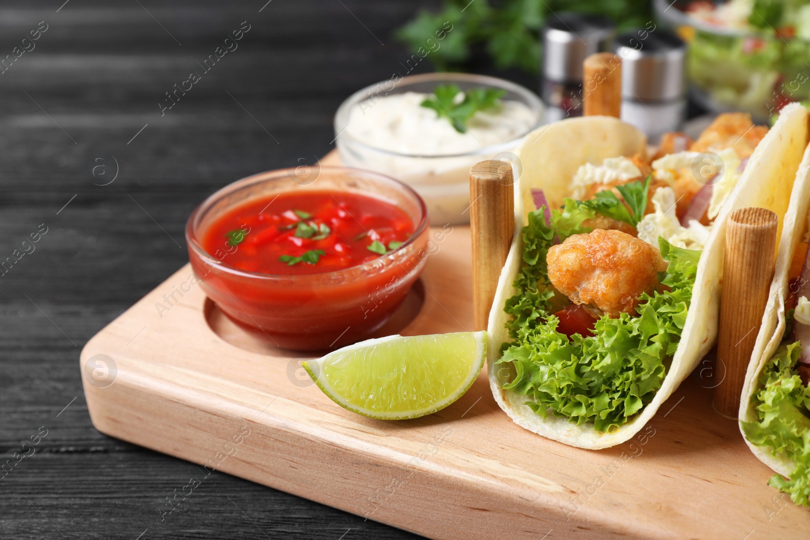 Delicious fish tacos served on dark wooden table, closeup Photo of Delicious fish tacos served on dark wooden table, closeup