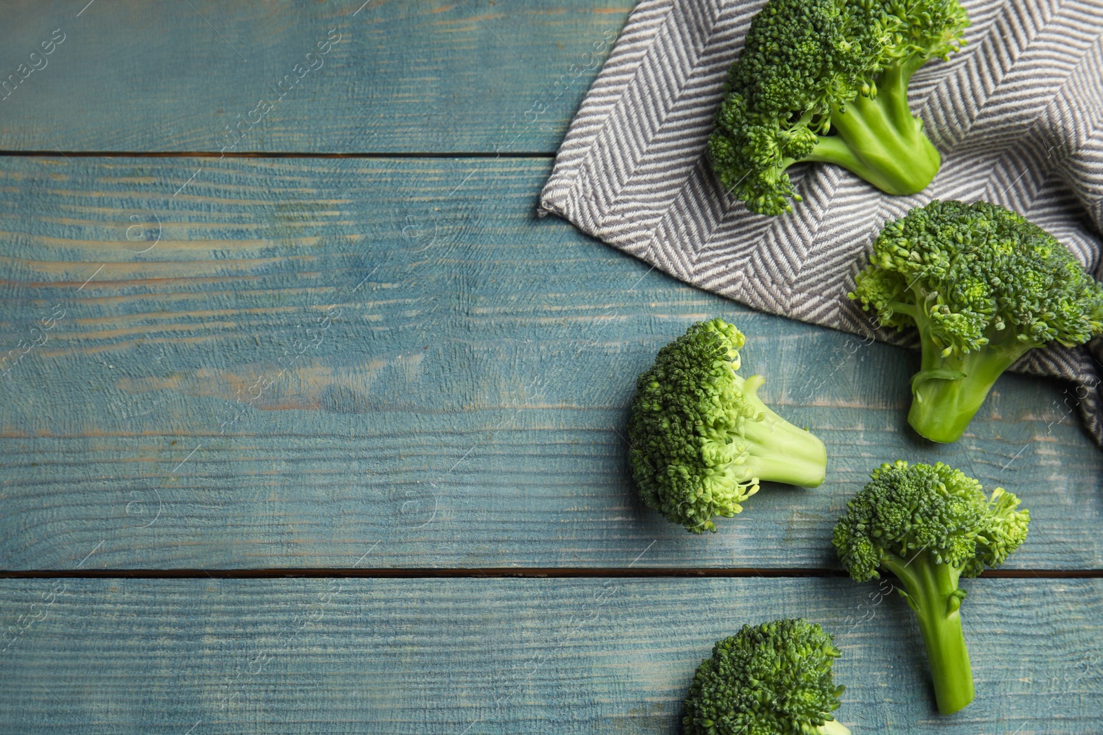 Fresh green broccoli on blue wooden table, flat lay. Space for text Photo of Fresh green broccoli on blue wooden table, flat lay. Space for text