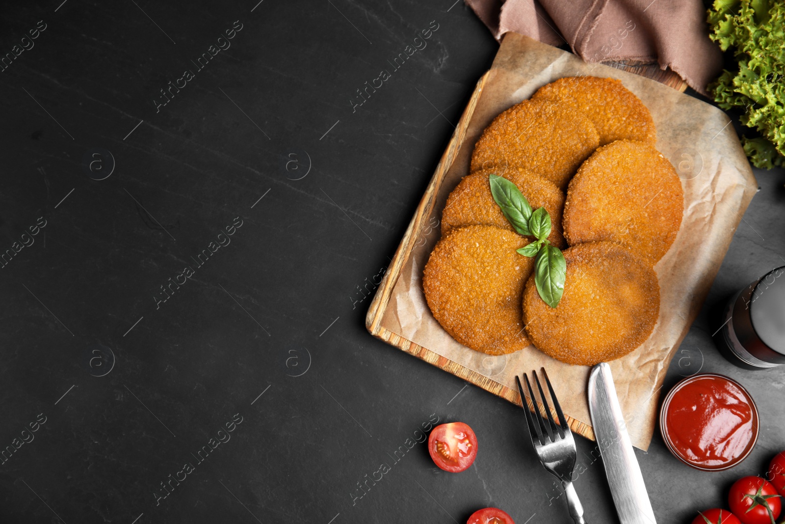 Delicious fried breaded cutlets served on black table, flat lay. Space for text Photo of Delicious fried breaded cutlets served on black table, flat lay. Space for text