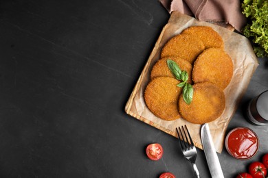Delicious fried breaded cutlets served on black table, flat lay. Space for text Photo of Delicious fried breaded cutlets served on black table, flat lay. Space for text