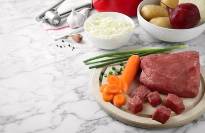 Fresh borscht ingredients on white marble table, space for text Photo of Fresh borscht ingredients on white marble table, space for text