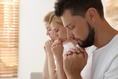 Group of religious people praying together indoors. Space for text Photo of Group of religious people praying together indoors. Space for text