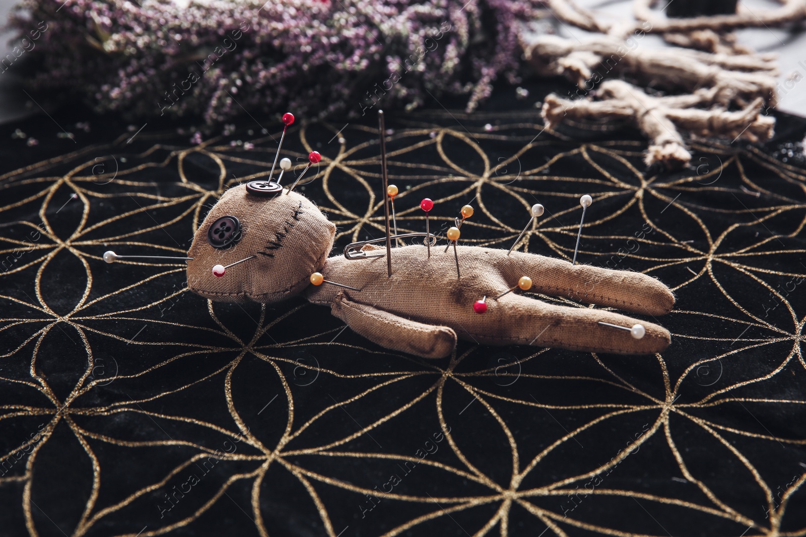 Voodoo doll pierced with pins on table. Curse ceremony Photo of Voodoo doll pierced with pins on table. Curse ceremony