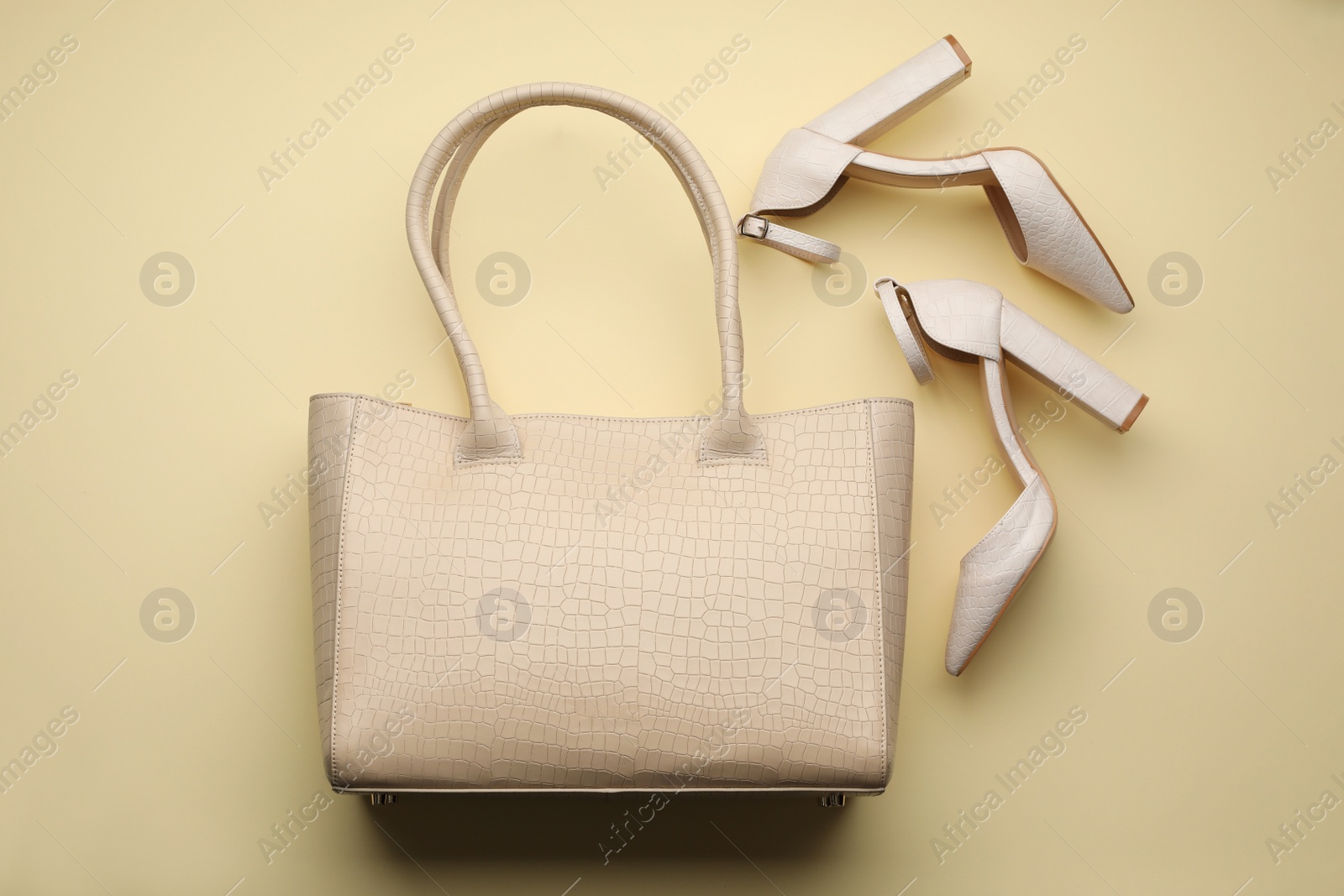Stylish woman's bag and shoes on beige background, flat lay Photo of Stylish woman's bag and shoes on beige background, flat lay