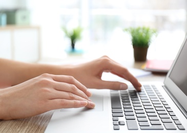 Young woman using laptop indoors, closeup Photo of Young woman using laptop indoors, closeup
