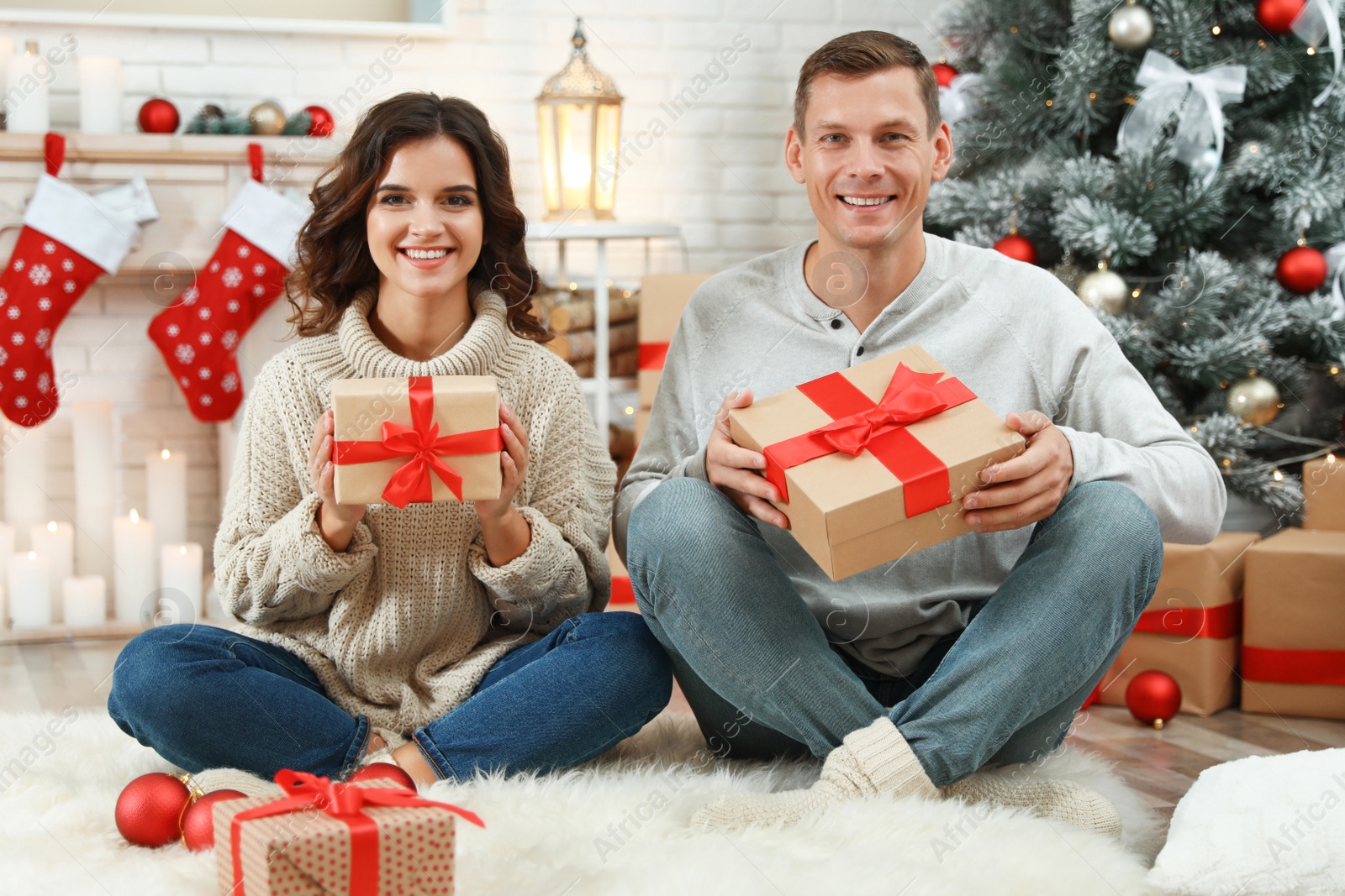 Happy couple with Christmas gifts at home Image of Happy couple with Christmas gifts at home