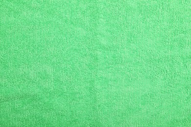 Photo of Light green microfiber cloth as background, top view