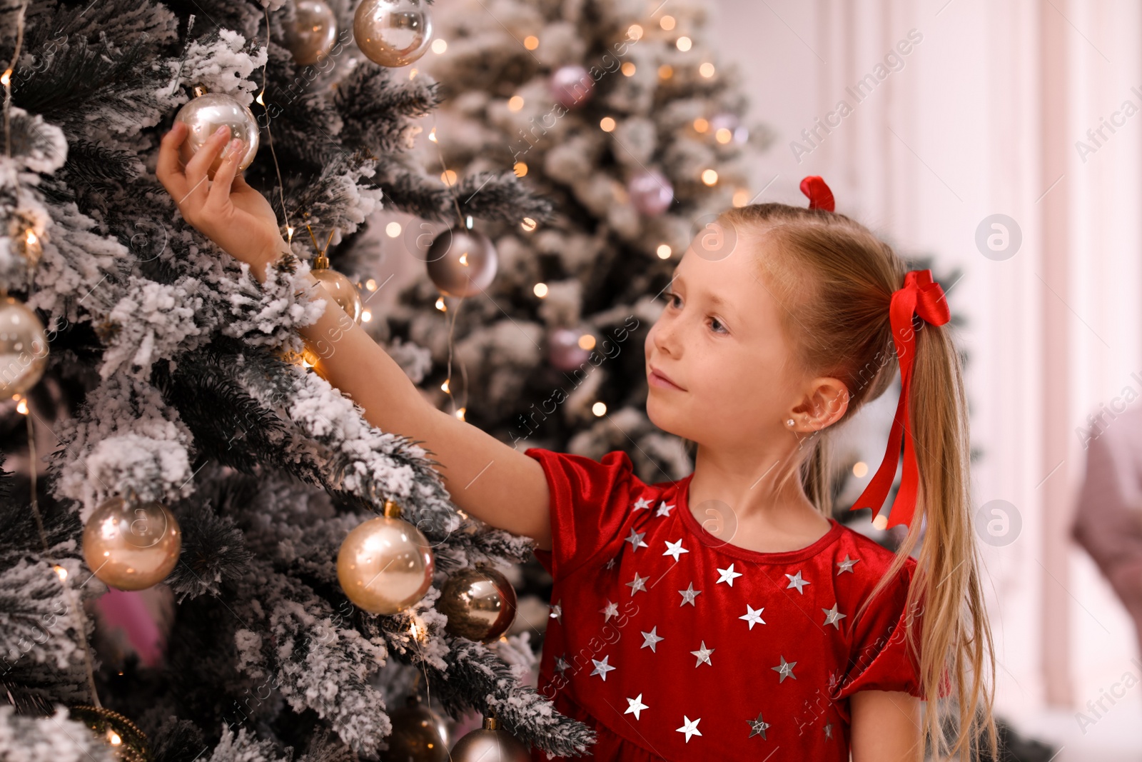 Cute little child near Christmas tree at home Photo of Cute little child near Christmas tree at home