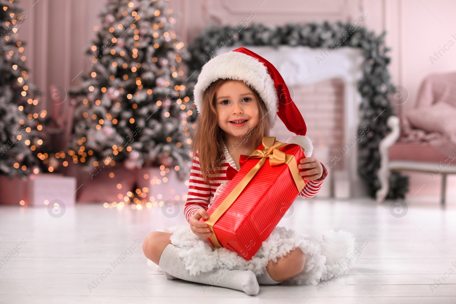 Cute little child with Christmas gift at home Photo of Cute little child with Christmas gift at home