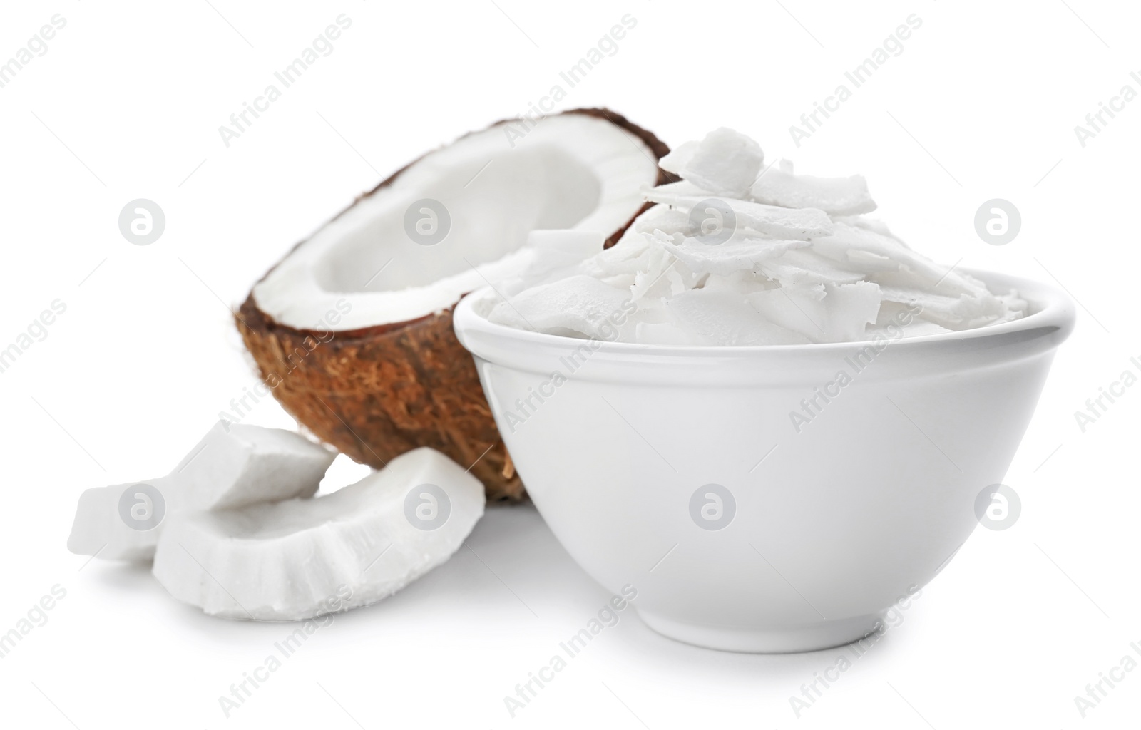 Fresh coconut flakes in bowl on white background Photo of Fresh coconut flakes in bowl on white background