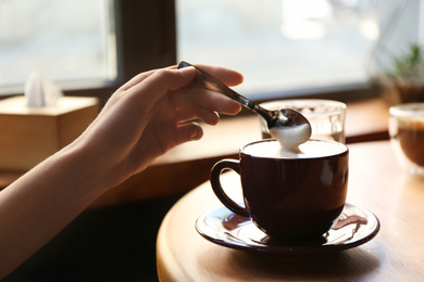 Woman with aromatic coffee at table in cafe, closeup Photo of Woman with aromatic coffee at table in cafe, closeup