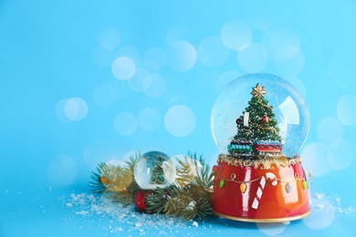 Beautiful Christmas snow globes on light blue background, bokeh effect. Space for text Image of Beautiful Christmas snow globes on light blue background, bokeh effect. Space for text