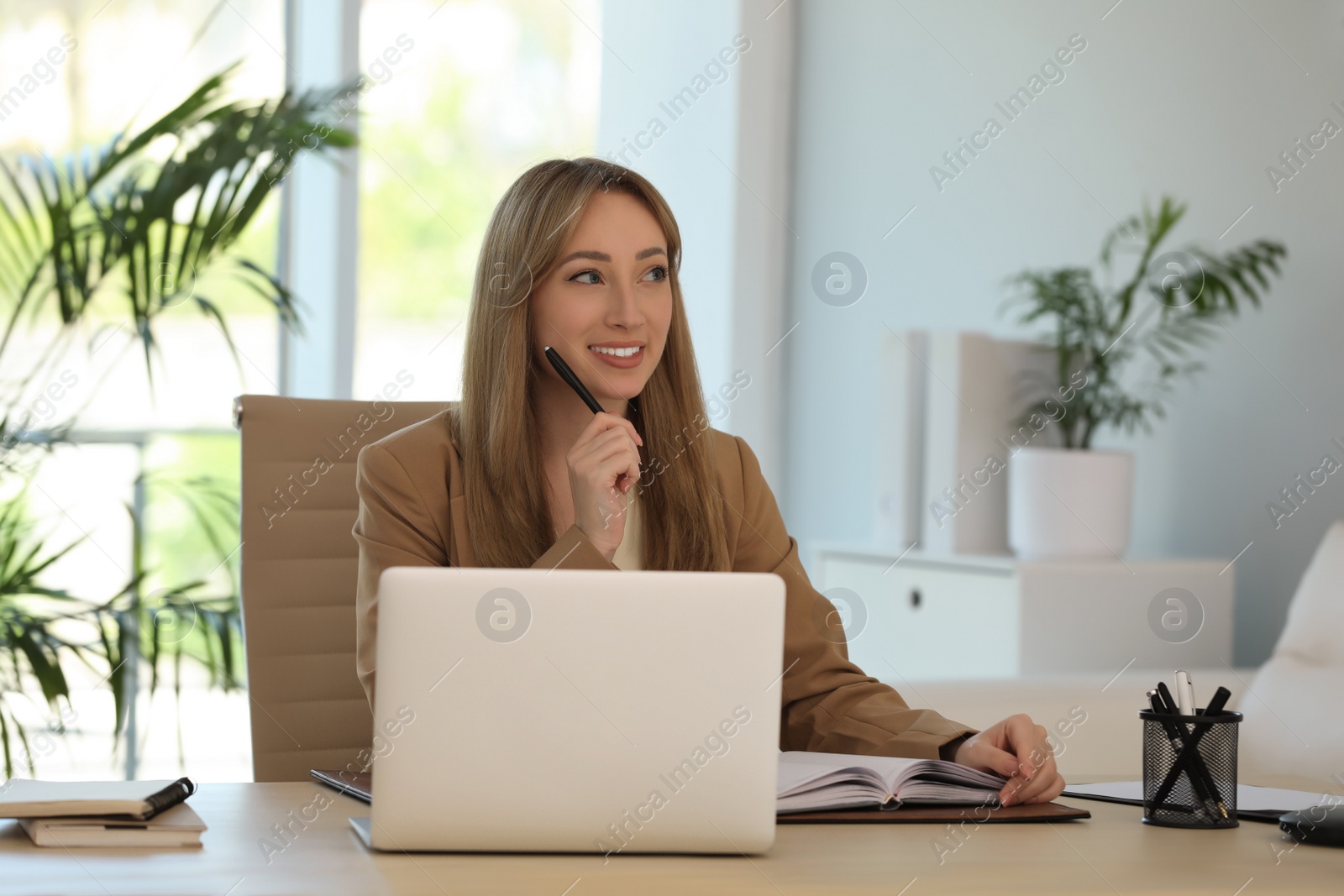Secretary working at wooden table in office Photo of Secretary working at wooden table in office