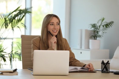 Secretary working at wooden table in office Photo of Secretary working at wooden table in office