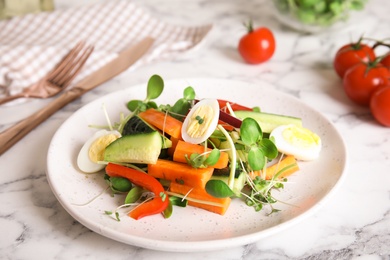 Salad with fresh organic microgreen in plate on white marble table, closeup Photo of Salad with fresh organic microgreen in plate on white marble table, closeup