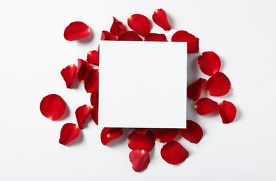 Blank greeting card and red rose petals on white background, top view. Valentine's day celebration Photo of Blank greeting card and red rose petals on white background, top view. Valentine's day celebration