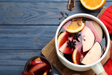 Delicious mulled wine and ingredients on blue wooden table, flat lay. Space for text Photo of Delicious mulled wine and ingredients on blue wooden table, flat lay. Space for text