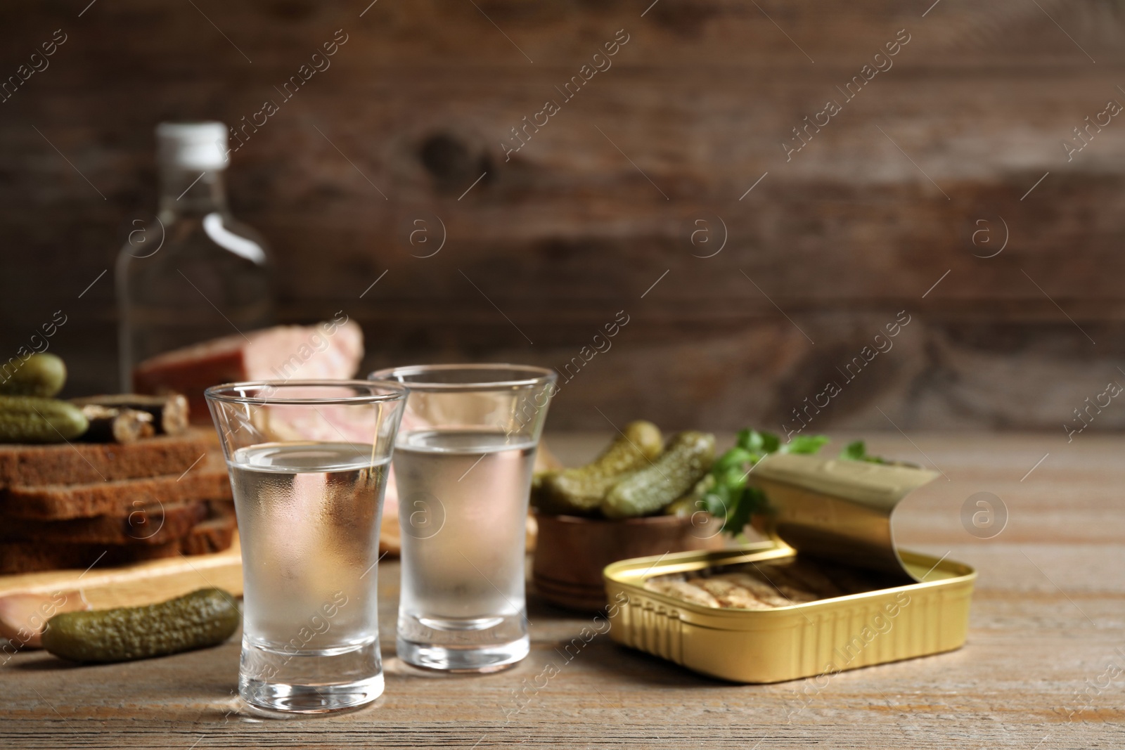 Cold Russian vodka with snacks on wooden table Photo of Cold Russian vodka with snacks on wooden table