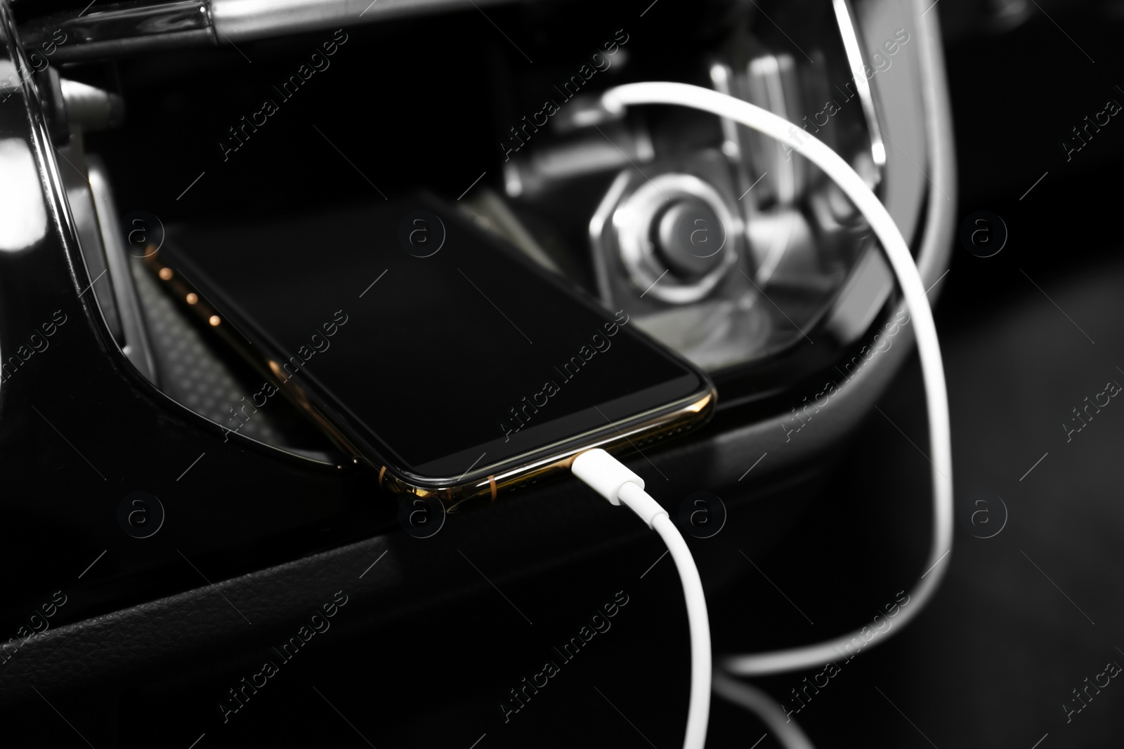 Smartphone with USB charging cable in modern car Photo of Smartphone with USB charging cable in modern car
