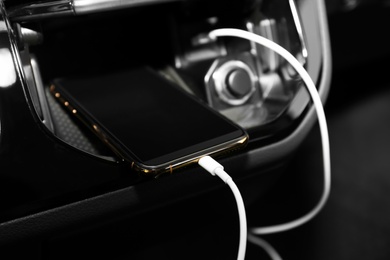Smartphone with USB charging cable in modern car Photo of Smartphone with USB charging cable in modern car