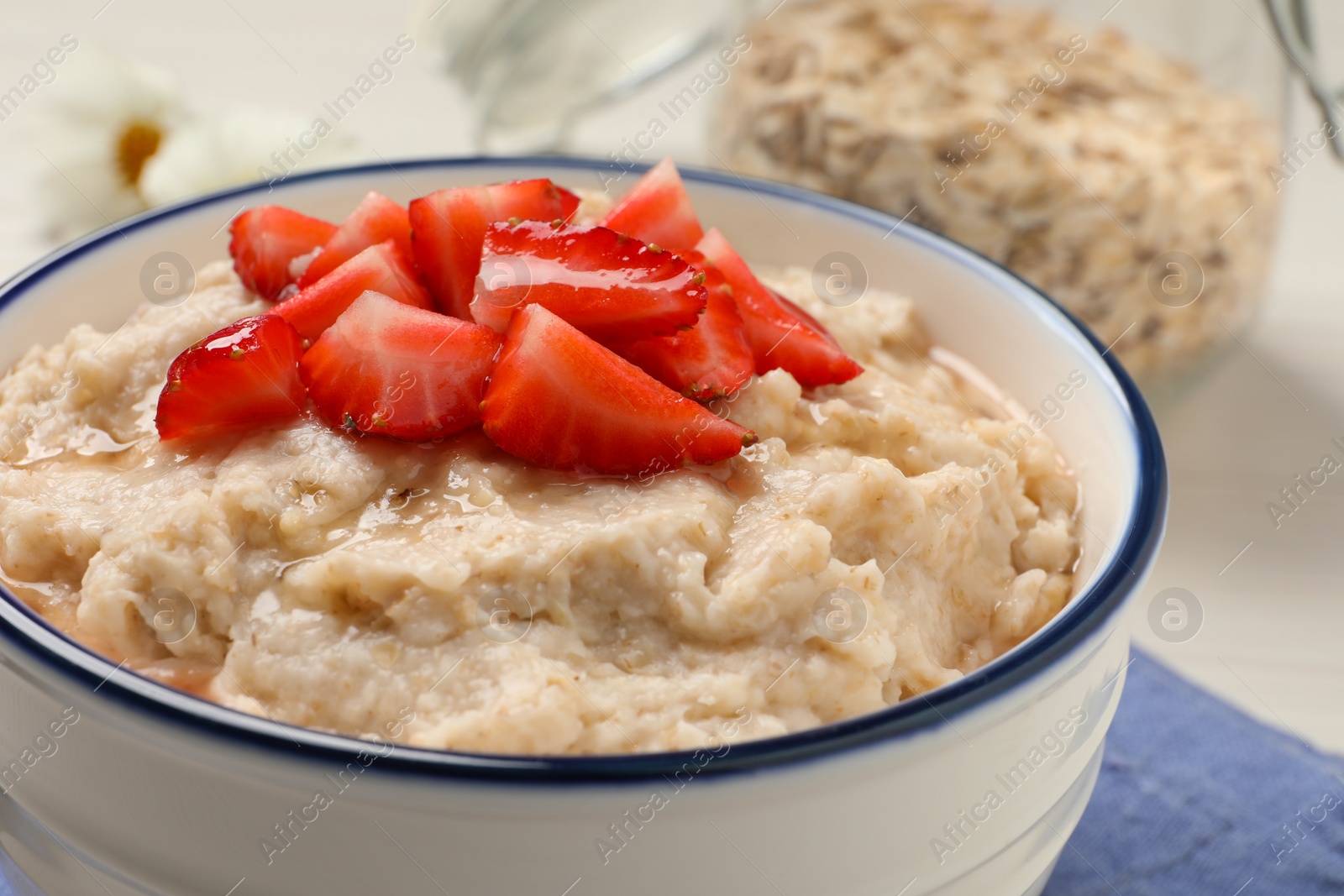Tasty oatmeal porridge with strawberries on table, closeup Photo of Tasty oatmeal porridge with strawberries on table, closeup