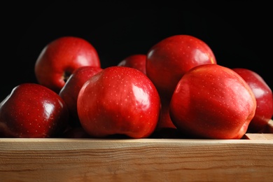 Wooden crate with fresh red apples on black background, closeup Photo of Wooden crate with fresh red apples on black background, closeup