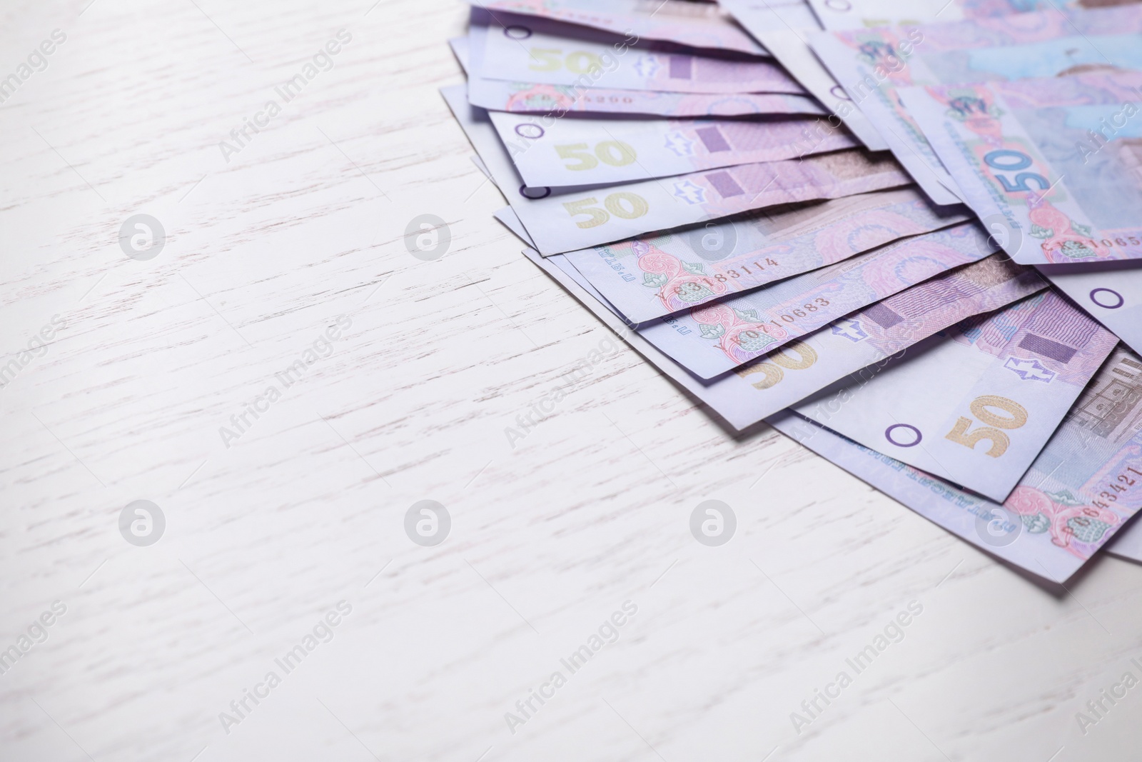 Ukrainian money on white wooden background, closeup. Space for text Photo of Ukrainian money on white wooden background, closeup. Space for text
