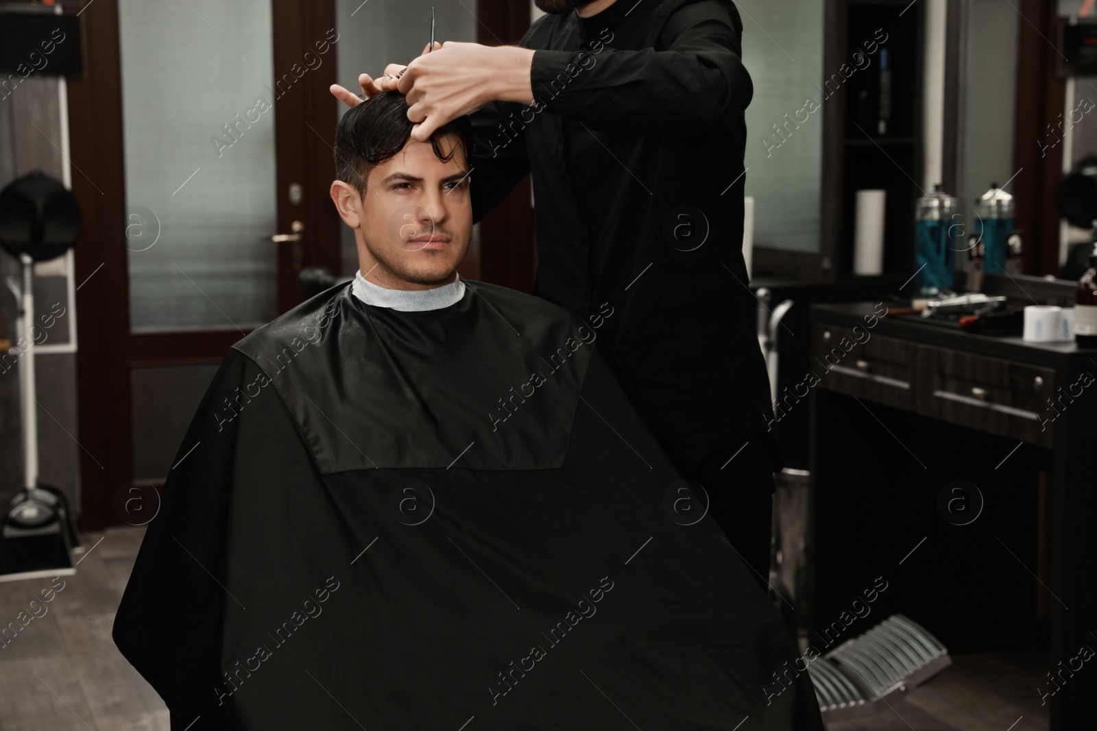 Professional hairdresser making stylish haircut in salon, closeup Photo of Professional hairdresser making stylish haircut in salon, closeup