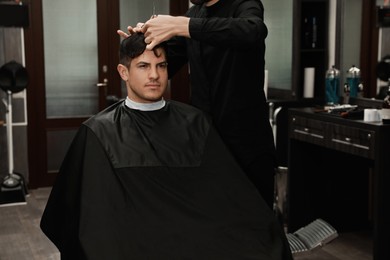 Professional hairdresser making stylish haircut in salon, closeup Photo of Professional hairdresser making stylish haircut in salon, closeup