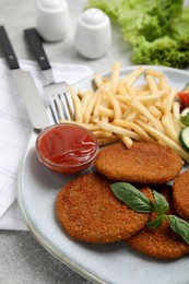 Delicious fried breaded cutlets with garnish on grey table, closeup Photo of Delicious fried breaded cutlets with garnish on grey table, closeup