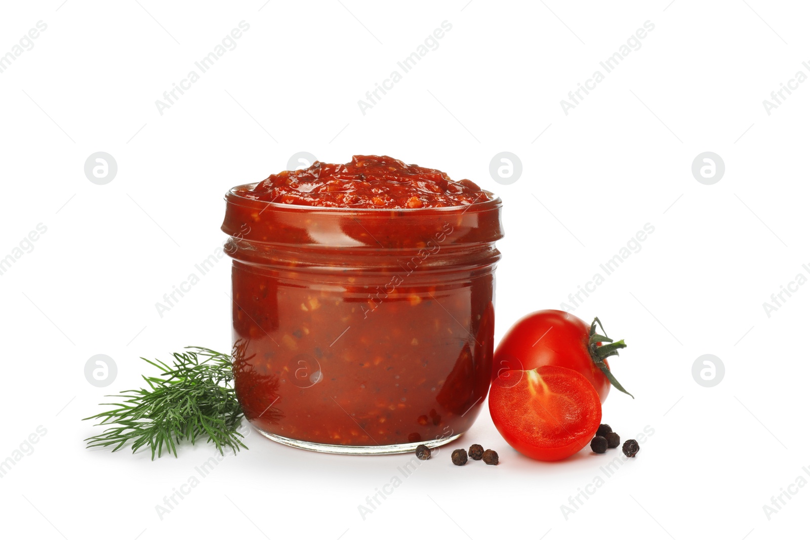 Delicious adjika sauce in glass jar and ingredients isolated on white Photo of Delicious adjika sauce in glass jar and ingredients isolated on white