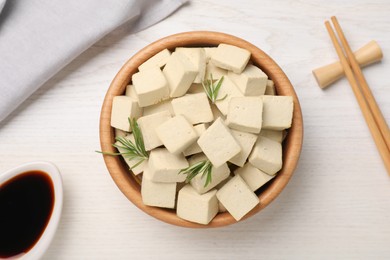 Delicious tofu with rosemary served on white wooden table, flat lay Photo of Delicious tofu with rosemary served on white wooden table, flat lay