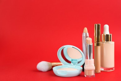 Foundation makeup products on red background, space for text. Decorative cosmetics Photo of Foundation makeup products on red background, space for text. Decorative cosmetics