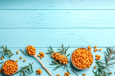 Flat lay composition with ripe sea buckthorn on light blue wooden table. Space for text Photo of Flat lay composition with ripe sea buckthorn on light blue wooden table. Space for text