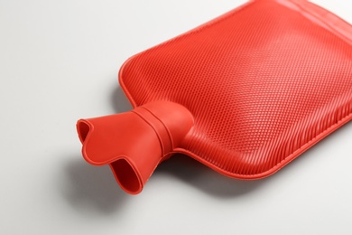 Red rubber hot water bottle on white background, closeup Photo of Red rubber hot water bottle on white background, closeup