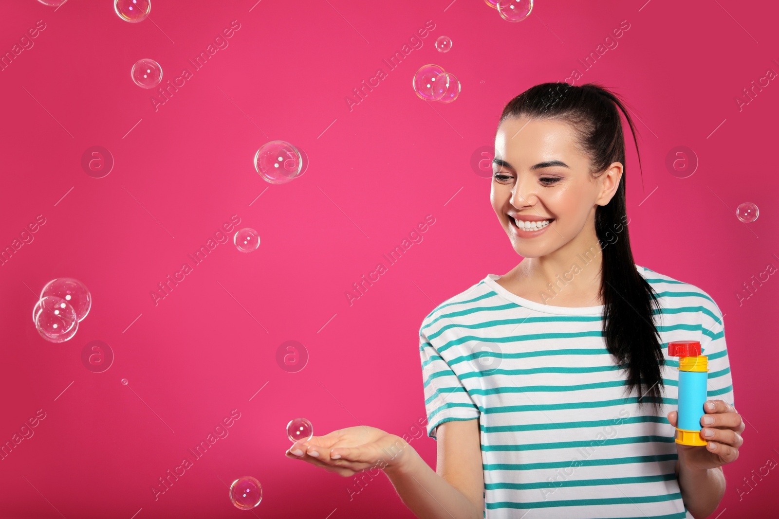 Young woman having fun with soap bubbles on pink background, space for text Photo of Young woman having fun with soap bubbles on pink background, space for text