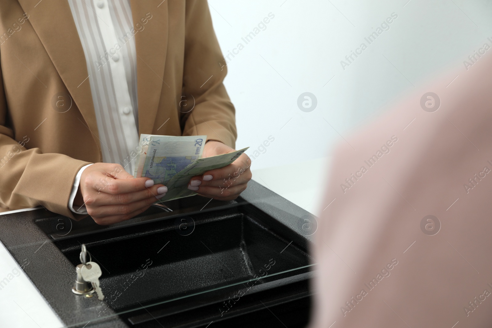 Cashier with money at currency department window in bank, closeup Photo of Cashier with money at currency department window in bank, closeup