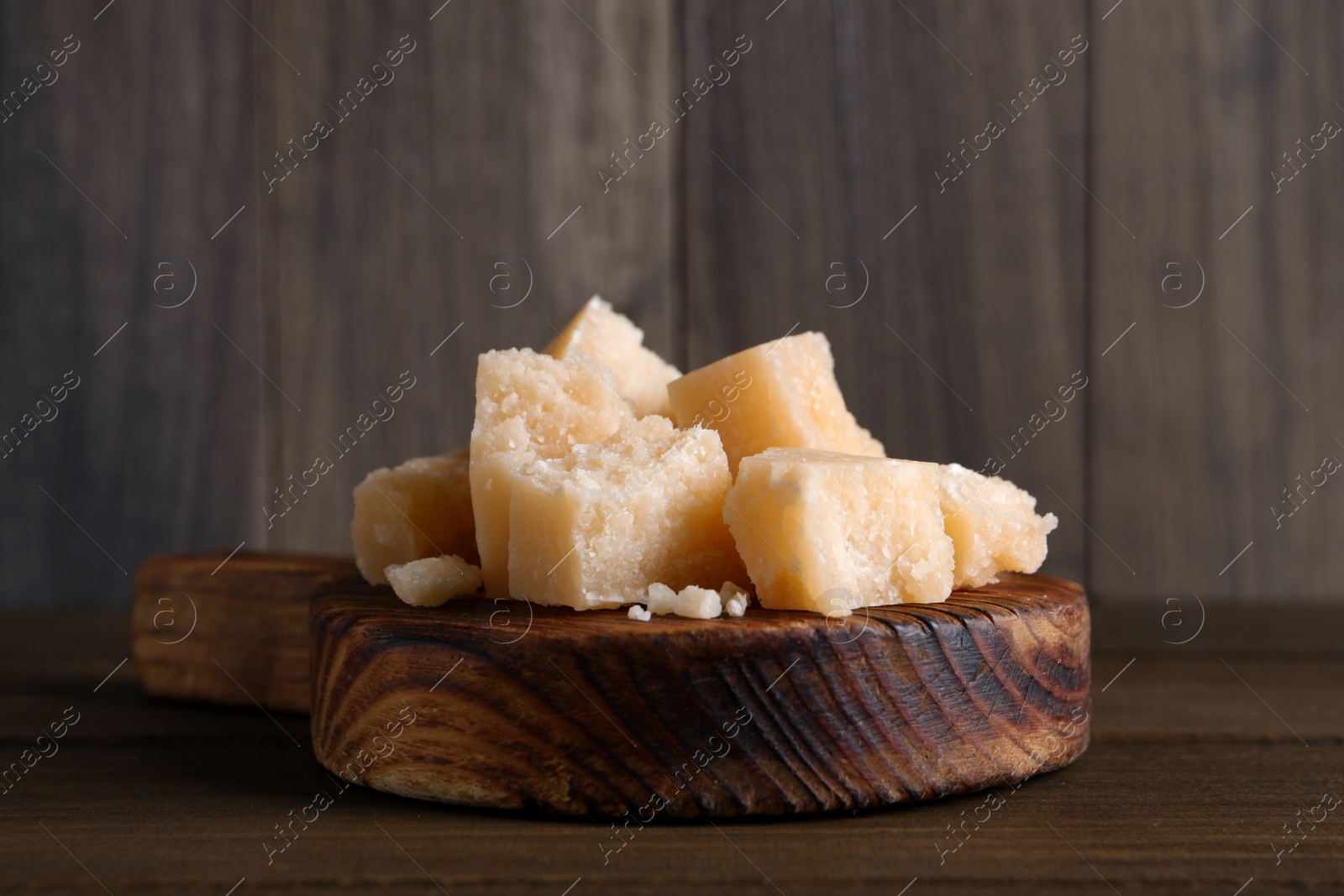 Pieces of delicious parmesan cheese on wooden table, closeup Photo of Pieces of delicious parmesan cheese on wooden table, closeup