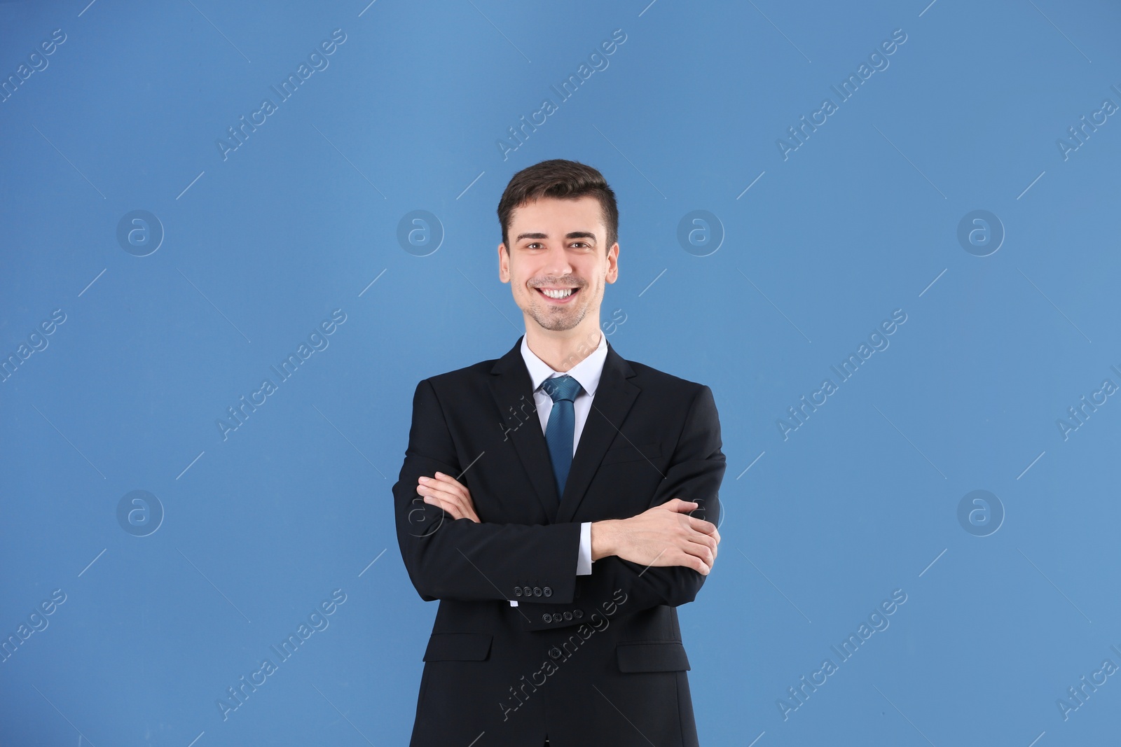 Business trainer with crossed arms on color background Photo of Business trainer with crossed arms on color background