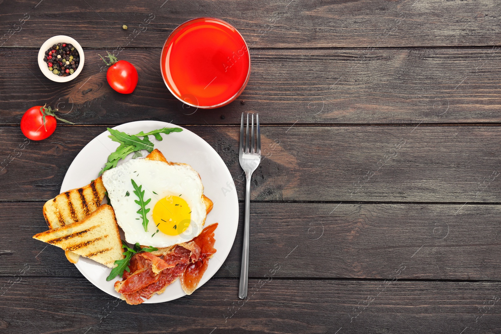 Plate with fried egg, bacon and toasts on wooden table Photo of Plate with fried egg, bacon and toasts on wooden table