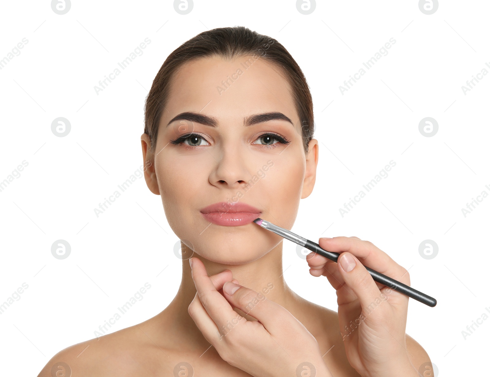 Visage artist applying makeup on woman's face against white background. Professional cosmetic products Photo of Visage artist applying makeup on woman's face against white background. Professional cosmetic products