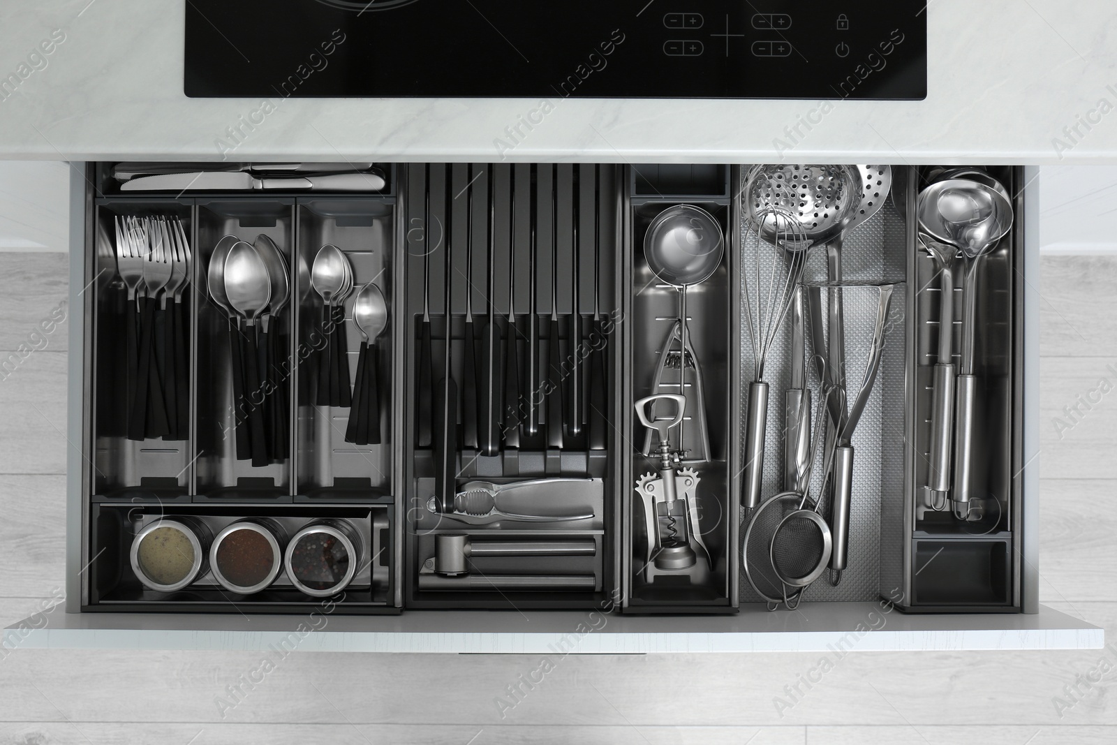 Drawer with stainless steel utensil set, top view. Order in kitchen Photo of Drawer with stainless steel utensil set, top view. Order in kitchen