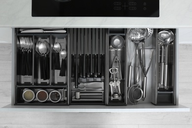 Drawer with stainless steel utensil set, top view. Order in kitchen Photo of Drawer with stainless steel utensil set, top view. Order in kitchen