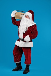 Santa Claus with vintage radio on blue background. Christmas music Photo of Santa Claus with vintage radio on blue background. Christmas music
