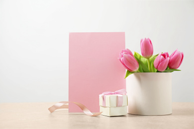 Blank greeting card, tulips and gift on table, space for text. Happy Mother's day Photo of Blank greeting card, tulips and gift on table, space for text. Happy Mother's day