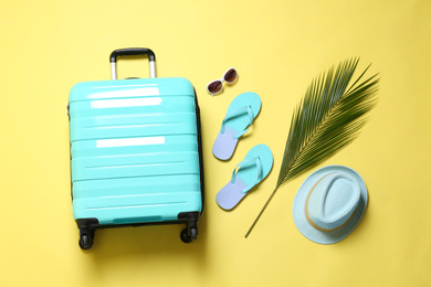Photo of Flat lay composition with suitcase on yellow background