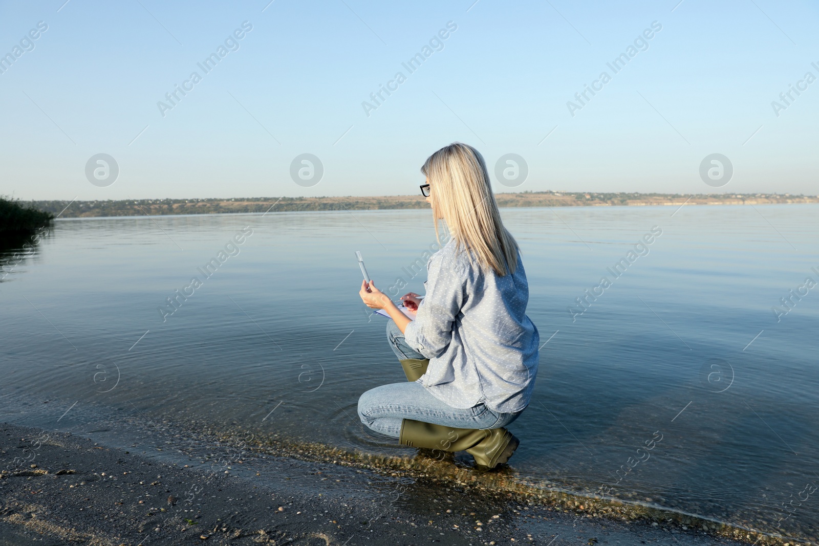 Scientist with clipboard and sample taken from river Photo of Scientist with clipboard and sample taken from river
