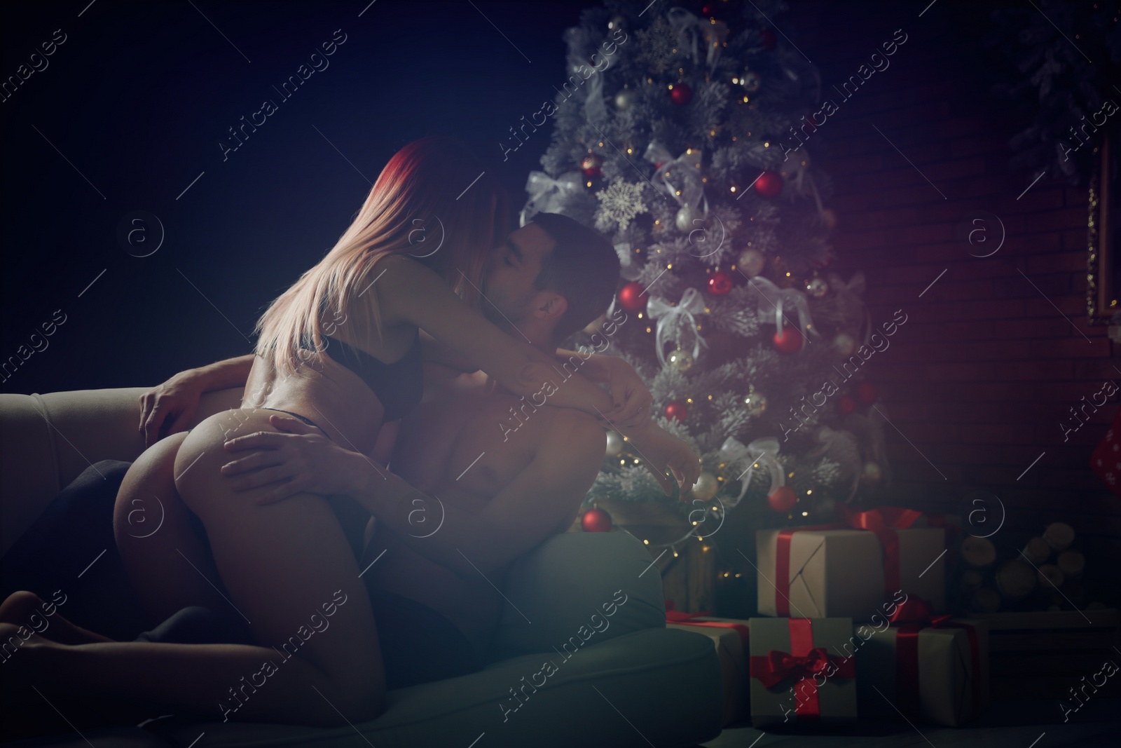 Passionate young couple enjoying each other at home, toned. Christmas celebration Image of Passionate young couple enjoying each other at home, toned. Christmas celebration